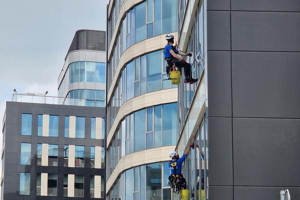 Rope-access window cleaners working on an office building