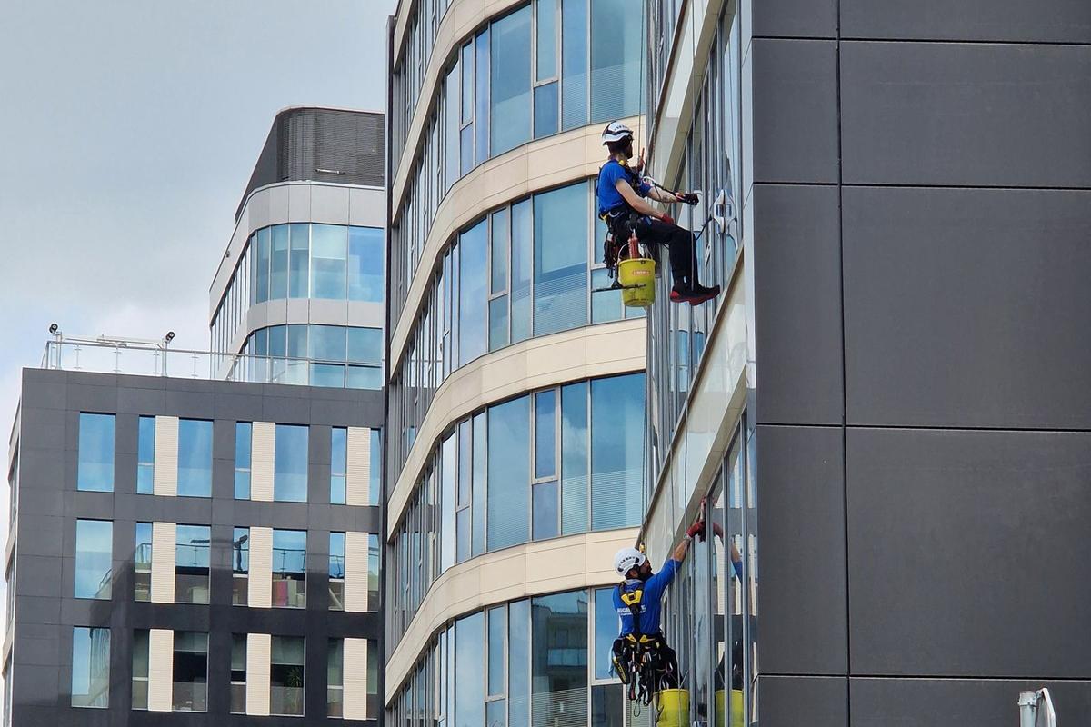 Rope-access window cleaners working on an office building